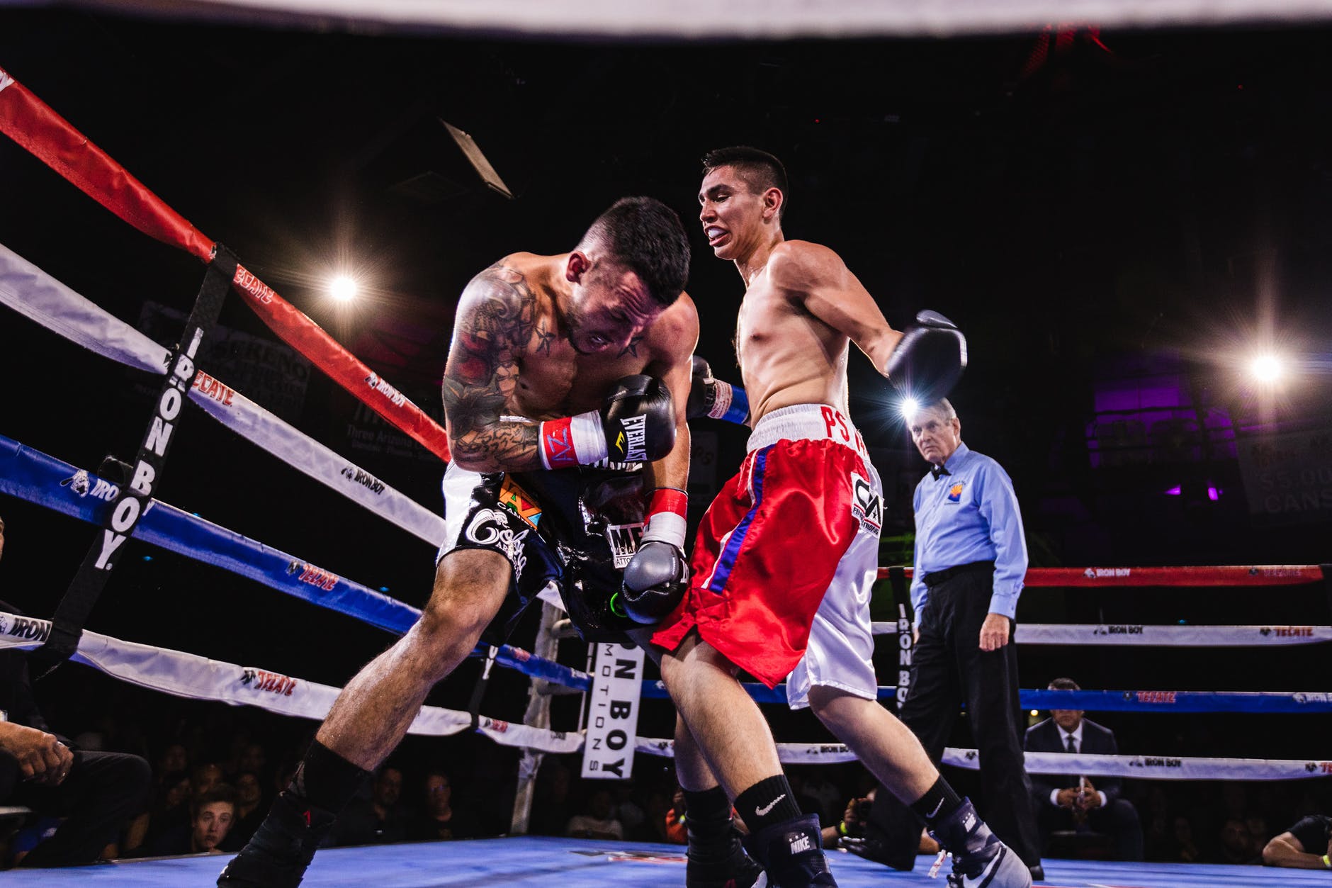 low angle photo of two men fighting in boxing ring