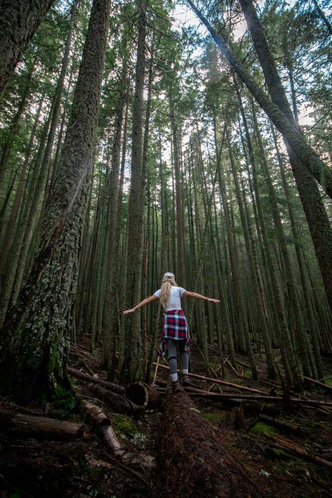 woman walking on a log in the forest