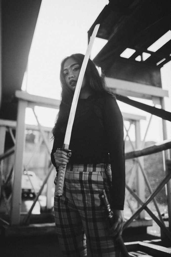 grayscale photo of woman holding katana